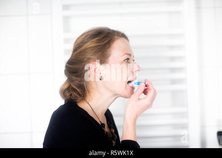 Femme debout dans la salle de bains nettoyer ses dents Banque D'Images