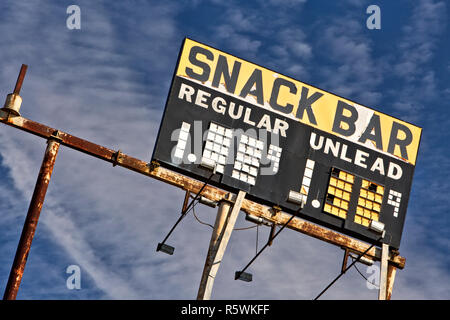 Station Vintage élevé signe 'Snack Bar - Régulier & Unlead' essence, contre un ciel bleu. Banque D'Images