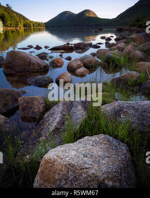 Lever du soleil un étang avec la Jordanie les bulles dans la distance à l'Acadia National Park, Maine. Banque D'Images