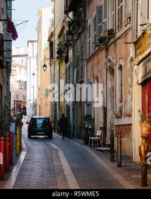 Voiture conduire loin vers le bas une ruelle étroite avec façades classique à Marseille, France Banque D'Images