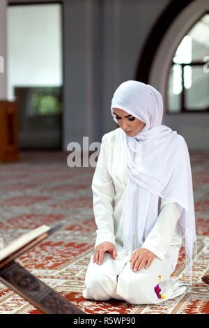 Jeune femme en prière qui tombe sur les genoux dans la mosquée Banque D'Images