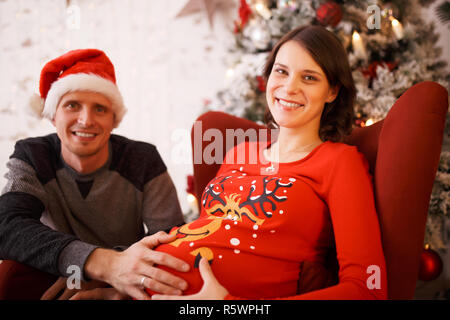 Image hommes dans Santa cap et Femme enceinte Banque D'Images