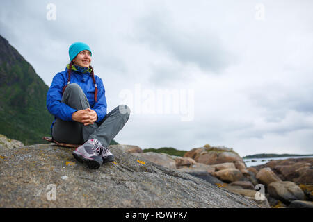 La photo d'une femme assis sur la colline sur fond de montagnes en automne Banque D'Images