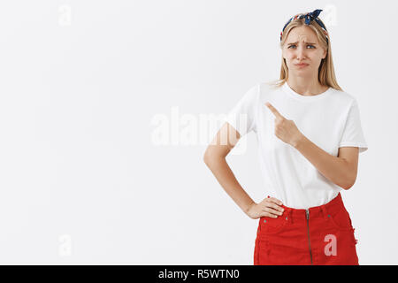 Portrait de mécontents et inquiets intense élégant blonde femme se plaindre de quelque chose elle n'aime pas méchant, en pointant le coin en haut à gauche où Banque D'Images