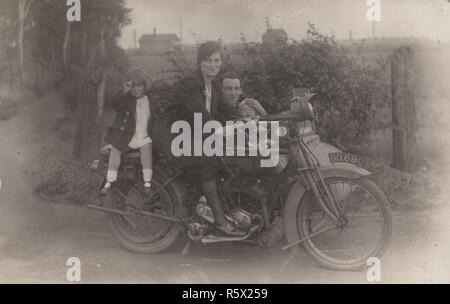 Vintage Carte postale photographique de la famille Perry assis sur une nouvelle moto d'Hudson et s'assit à l'intérieur du side-car. Banque D'Images