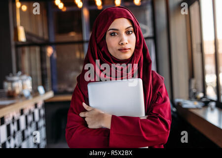 Confiant dans femme hijab avec coffre intérieur permanent dans un restaurant. Femme en hijab islamique du coffee shop. Banque D'Images