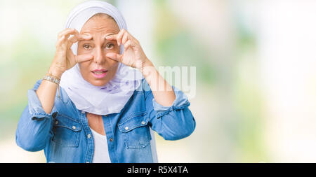 L'âge moyen est de l'arabe arabe femme portant le hijab sur fond isolé d'essayer d'ouvrir les yeux avec les doigts, de somnolence et de fatigue La fatigue du matin Banque D'Images
