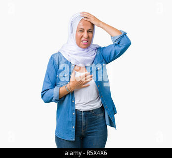 L'âge moyen est de l'arabe arabe femme portant le hijab sur fond isolé Touching forehead pour maladie et la fièvre, la grippe et le froid, malade du virus Banque D'Images