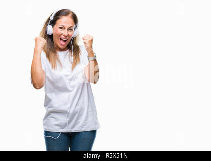 L'âge moyen hispanic woman wearing headphones sur fond isolé très heureux et excité de faire geste gagnant avec bras levés, Banque D'Images