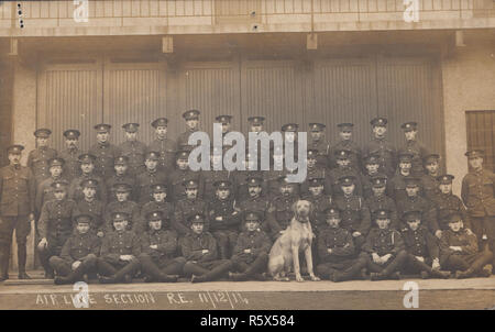 * Vintage Carte postale photographique de WW1 Soldats de l'armée britannique. La section de ligne aérienne, Royal Engineers, 11 décembre 1914. Mascotte Chien Dogue Allemand. Banque D'Images