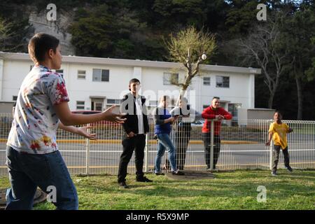 YOKOSUKA, Japon (14 avril 2017) - Spécialiste des opérations Seaman Jacob Powell, de Fall River Mills, en Californie, attaché au commandant de la 7e Flotte, montre aux enfants comment mélanger des oeufs à une chasse aux oeufs de Pâques organisée par l'Association des officiers mariniers de première classe. Blue Ridge est dans une vaste période de constitution en vue de moderniser le navire de continuer à servir de plate-forme de communication robuste dans la 7e flotte américaine zone d'opérations. Banque D'Images