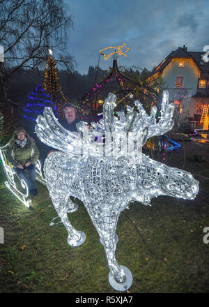 01 décembre 2018, le Brandebourg, Vacances Berkenbrück : Gabriele et Harald Muschner peut être vu dans leur jardin derrière un grand allumé l'orignal et le traîneau. Fairy lights, glowing stars et décorées d'arbres de Noël sont pour beaucoup de gens une partie de la pré-saison de Noël. Mais ce que la famille fait chaque année Muschner dans Advent est extraordinaire. Fans de Noël sont loin d'en avoir fini avec leurs idées de décoration. Photo : Patrick Pleul/dpa-Zentralbild/dpa Banque D'Images