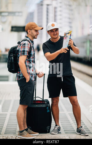 Deux backpackers d'examiner une carte at train station Banque D'Images