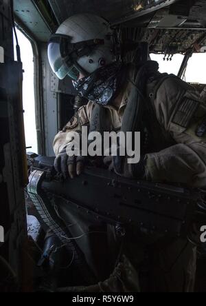 Le Golfe Arabique (20 avril 2017) Aircrewman de marine 2e classe Bob Shannon, affecté à l'hélicoptère de la lutte contre les mines (HM) de l'Escadron 15 2 Détachement, numérise l'horizon pour les contacts alors que Manning une XM-218 de calibre 50 canon sur un MH-53E Sea Dragon tout en menant la formation au large de la côte de Bahreïn. HM-15 est assigné à la Force 52, la promotion des activités de lutte contre les mines dans la 5e flotte américaine zone d'opérations. Banque D'Images