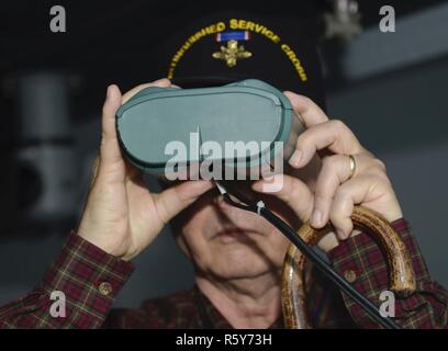 L'Armée américaine à la retraite 1er Sgt. Claude, rapide, membre de la Légion de la vaillance regarde à travers des jumelles de simulation à l'Intermodal maritime Ministère de la formation tandis que sur un tour à Joint Base Langley-Eustis, en Virginie, le 21 avril 2017. Chaque année, les membres de la Légion de la vaillance se rassemblent pour une convention annuelle afin d'améliorer leur compréhension des affaires militaires et offrent des services de mentorat de réalisations personnelles ou des échecs. Banque D'Images