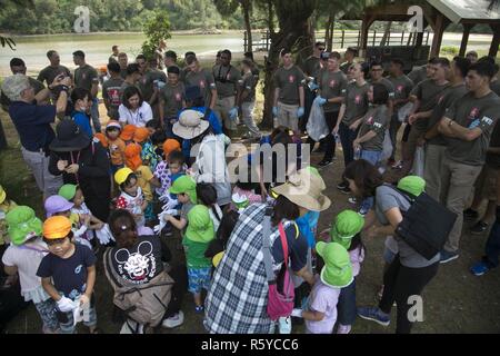 Les membres de la communauté militaire, les enfants des établissements préscolaires et les résidents locaux se réunissent pour un Okinawa le jour de la Terre et la plantation d'arbres, nettoyage 21 avril au Nature Mirai Kan en ville Kin, Okinawa, Japon. Environ 100 participants ont ramassé les ordures le long de la rivière et Okukubi plantées de jeunes arbres de la mangrove à côté du lit de la rivière. Petites lacunes dans les racines de la mangrove fournissent une protection pour les petits poissons, car les gros poissons ne peuvent pas monter en entre eux. Banque D'Images