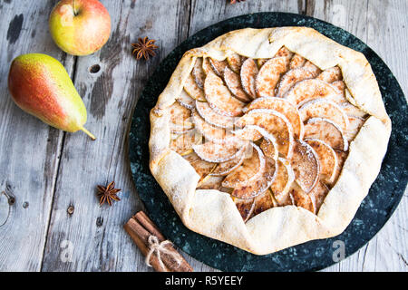 Tourte aux pommes, poires et cannelle sur un vieux fond de bois Banque D'Images