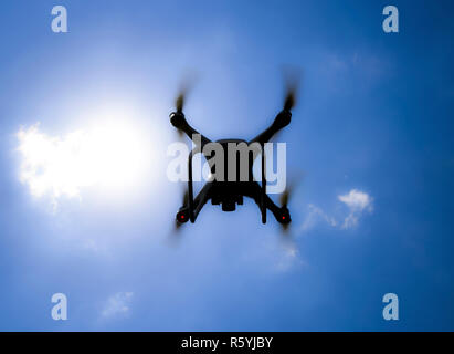 Drone DJI Phantom 4 en vol. Quadrocopter contre le ciel bleu Banque D'Images