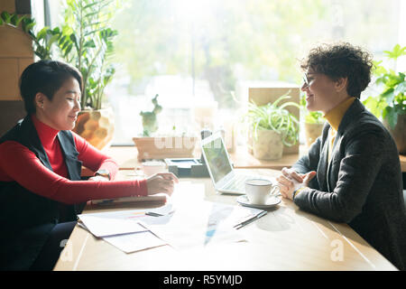 Rapport contenu businesswomen discussing in cafe Banque D'Images