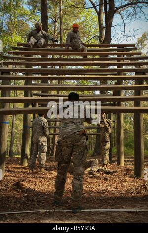 Le sergent de l'armée américaine. Hénoc Fleites, un spécialiste de la production de documents ou de combat, affecté à la 55e Compagnie de transmissions (documents) de la Caméra de combat, le s.. Edward Reagan, affecté à la 982e Caméra de combat, à travers toute la weaver obstacle à la course à obstacles au cours de l'événement 2017 5e édition de la SPC Hilda I. Clayton Meilleur Combat Camera (COMCAM) à Fort A.P. Hill, en Virginie, le 18 avril 2017. Reagan est en compétition dans le 2017 5e meilleur COMCAM où la concurrence de deux équipes en concurrence tout au long d'une semaine que les tests leur santé physique, mentale et les capacités techniques. La compétition Banque D'Images