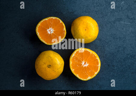 Quatre moitiés d'une orange sur une pierre bleue Banque D'Images