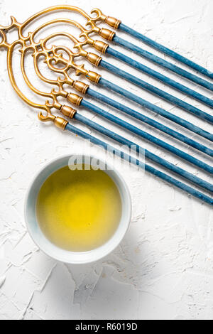 En laiton avec Hanukkah Menorah bougies bleu et le beurre dans un bol haut afficher Banque D'Images