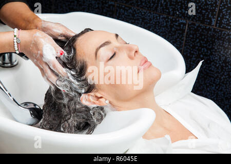 Femme blanche obtenir une procédure de lavage de cheveux dans un salon de beauté Banque D'Images