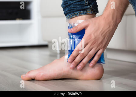 Person's Hand Holding Ice Pack Gel Sur la cheville Banque D'Images