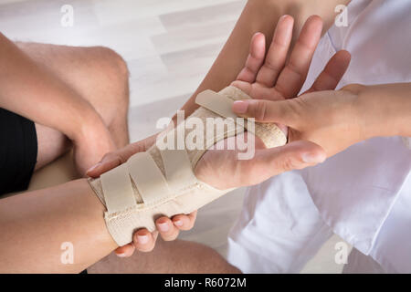 Fixation à l'orthopédiste le plâtre sur la main de la personne blessée Banque D'Images