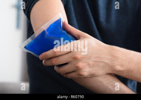 Personne l'application de glace sur un gel au coude blessé Banque D'Images