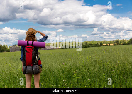 Jeune femme avec sac à dos en randonnée dans la campagne environnante. Concept de voyage sans stress. Banque D'Images