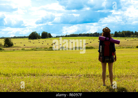 Jeune femme avec sac à dos en randonnée dans la campagne environnante. Concept de voyage sans stress. Banque D'Images