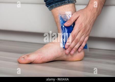 Person's Hand Holding Ice Pack Gel Sur la cheville Banque D'Images