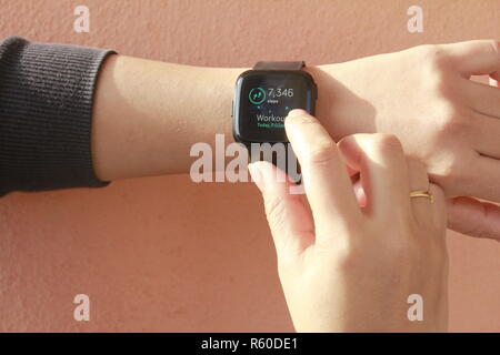 Femme à l'aide de smart watch (Fitbit) Banque D'Images