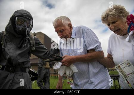 Deux acteurs civils sont escortés par un soldat de l'armée américaine avec la 51e Compagnie Chimique, biologique, radiologique et nucléaire, de Fort Stewart, en Géorgie, à un champ de décontamination site durant 17 à la réponse gardien Muscatatuck Urban Training Center, Indiana, le 27 avril 2017. Réponse d'un tuteur, dans le cadre de réponse dynamique, est un exercice d'entraînement multi-composants gérés par l'armée américaine Réserver conçu pour valider près de 4 000 membres du service à l'appui de la défense aux autorités civiles (DSCA) dans le cas d'un produit chimique, biologique, radiologique et nucléaire (CBRN) catastrophe. Si l'exercice de cette année. Banque D'Images