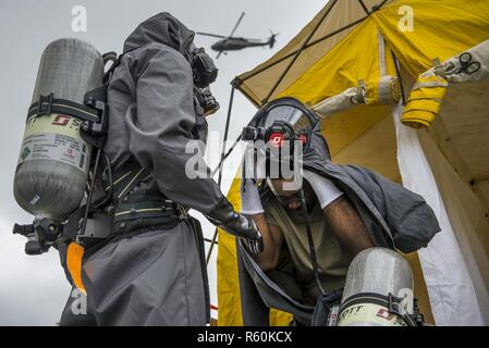 La FPC. Khalid Harrison, un soldat de l'armée américaine avec la 51e Compagnie Chimique, biologique, radiologique et nucléaire, de Fort Stewart, Géorgie, enlève son costume de décontamination chimique pendant 17 à la réponse gardien Muscatatuck Urban Training Center, Indiana, le 27 avril 2017. Réponse d'un tuteur, dans le cadre de réponse dynamique, est un exercice d'entraînement multi-composants gérés par l'armée américaine Réserver conçu pour valider près de 4 000 membres du service à l'appui de la défense aux autorités civiles (DSCA) dans le cas d'un produit chimique, biologique, radiologique et nucléaire (CBRN) catastrophe. L'exercice de cette année simuler Banque D'Images