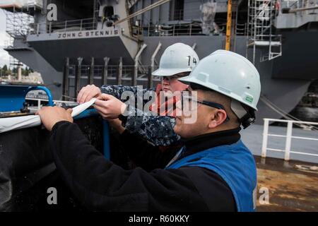 BREMERTON, Washington (26 avril 2017) Maître de Manœuvre Seaman Hugo Saenz, de Chicago, et Andrew Seaman, Starling de Bunn, Caroline du Nord, préparer un panier grue pour utilisation dans la préservation d'entretien sur l'USS JOHN C. STENNIS (CVN 74) plage arrière. John C. Stennis mène une disponibilité progressive prévue (PIA) au chantier naval de Puget Sound et l'Installation de maintenance de niveau intermédiaire, au cours de laquelle le navire est soumis à des activités de maintenance et de mise à niveau. Banque D'Images