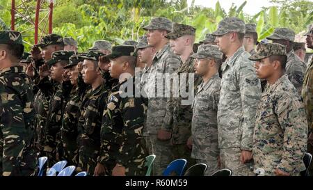 Soldats philippins et américains pour le génie militaire hymne national des Philippines au cours d'une cérémonie d'inauguration des travaux de Balikatan 2017 à Ormoc City, Leyte, le 25 avril 2017. Les dirigeants de l'Armée des Philippines, l'armée américaine, et d'Ormoc City se sont réunis pour commémorer le début de projets d'ingénierie pour les nouvelles classes de margen Elementary School à Ormoc City. Balikatan est un américain annuel-armée philippine exercice bilatéral axé sur une grande variété de missions, y compris l'aide humanitaire et des secours en cas de catastrophe et le terrorisme. Banque D'Images