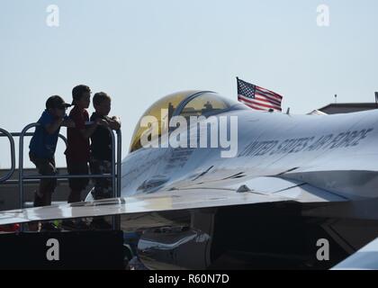 Trois jeunes enfants regarder un U.S. Air Force Escadron de démonstration aérienne Thunderbird F-16 Falcon au cours de la côte du golfe 2017 Salute open house et le spectacle aérien le 22 avril 2017 à la base aérienne Tyndall, en Floride pendant le spectacle aérien, les Thunderbirds ont accompli leur démonstration aérienne de renommée mondiale pour les aviateurs, marins, marines, soldats, Coastguardsmen, les anciens combattants et les visiteurs présents dans la célébration de l'Armée de l'air 70e anniversaire. Banque D'Images