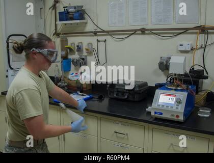 Airman Senior Courtney, 380e Escadron expéditionnaire de préparation logistique Services Carburants Technicien de laboratoire, agite un échantillon de JP-TS pour les tests lors de l'affichage des résultats d'un essai séparé le 25 avril 2017, dans un endroit inconnu en Asie du Sud-Ouest. Pour assurer la meilleure qualité possible, à plusieurs reprises des spécialistes de laboratoire des échantillons de test, les réservoirs de carburant pour les contaminants avec une variété d'équipements high-tech. Banque D'Images