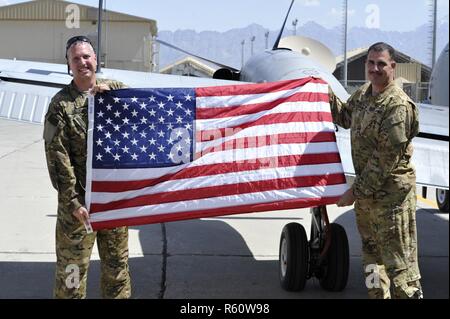 L'AÉRODROME DE BAGRAM, en Afghanistan (28 avril 2017) - L'Adjudant-chef de l'armée américaine Bureau 4 John Aloi et David Spielman afficher les couleurs du pays qui a volé avec eux à la fois sur l'Aloi vol militaire finale. Aloi est posé le Groupe de travail ODIN/206e bataillon de renseignement militaire RC-12X Garde-corps avions ici aujourd'hui pour la dernière fois. Aloi va redéployer rapidement et de prendre sa retraite de l'Armée de l'année prochaine. Spielman co-pilote du vol avec son ami et collègue. Banque D'Images