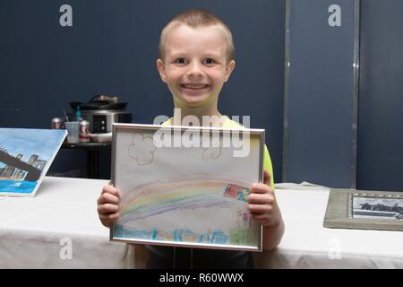 Jeune artiste Gavin affiche fièrement son oeuvre donné pour les fonds de soutien bénévole encan silencieux au cours de la 26e Festival international annuel d'aliments à la Chambre des communes le 28 avril Fort Drum. Gavin et sa mère a fait don à la fois une illustration originale pour la vente aux enchères, qui aide à recueillir des fonds pour le FSV. Banque D'Images