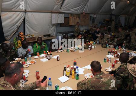 Les hauts dirigeants d'enrôlés les Forces armées Nigeriennes et sous-officiers supérieurs de l'US Air Force déployée pour le 724e Escadron de la base aérienne expéditionnaire profitez de la conversation lors d'un déjeuner organisé à la Base Aérienne 201 Nigériens, Niger, 19 avril 2017. Le déjeuner est organisé tous les mois, les endroits entre le ventilateur et l'EABS 724e, afin de partager leurs préoccupations et d'établir des partenariats. Banque D'Images