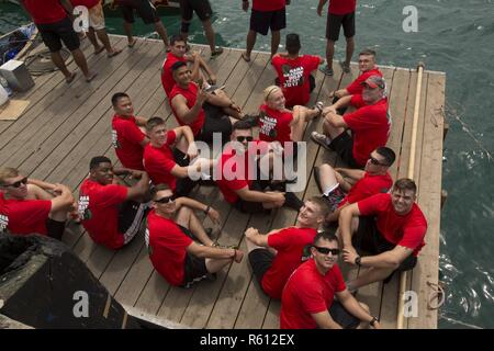 Les membres de l'unique du programme marin de l'équipe de bateau-dragon pose pour une photo alors qu'il était assis sur un quai en attente à bord d'un bateau dragon au cours de la 43e Festival Razafindrakoto Naha Dragon Boat Race le 5 mai dans la ville de Naha, Okinawa, Japon. Les Marines avaient 10 pratiques tout au long de un mois et demi avant la course. Pendant les pratiques les Marines ont travaillé sur leur technique et le rythme. Banque D'Images