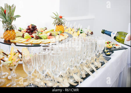 Un beau fruit bar servant une table de fête. Le serveur verse du Champagne dans des verres à vin Banque D'Images