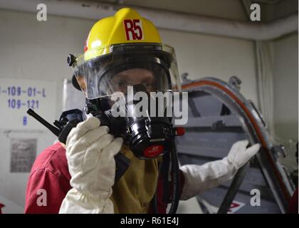 À BORD DU USS Blue Ridge (nov. 27, 2018) - 7e flotte américaine navire amiral USS Blue Ridge (CAC 19) Marin, dommage Controlman 2e classe George Carter, de Norman, OK communique via une radio bidirectionnelle lors d'un forage de gaz toxiques. Blue Ridge est le plus ancien navire opérationnel dans la marine, et comme 7e flotte navire de commandement, est chargé de patrouiller et de favoriser les relations au sein de l'Indo-Asia Région du Pacifique. Banque D'Images