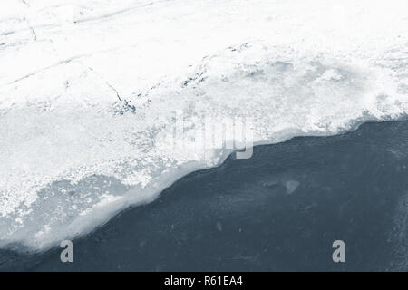 Bord de la glace couverte de neige sur la rivière gelée en hiver, la texture naturelle de fond photo Banque D'Images