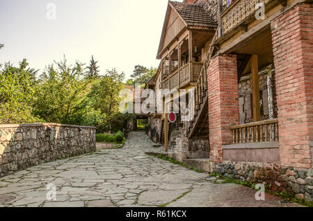 Dilijan,Arménie,Août 24,2018 : Petits commerces dans la rue dans le vieux Sharambeyan maisons faites de pierres et de briques colonnes,avec un balcon en bois sculpté Banque D'Images