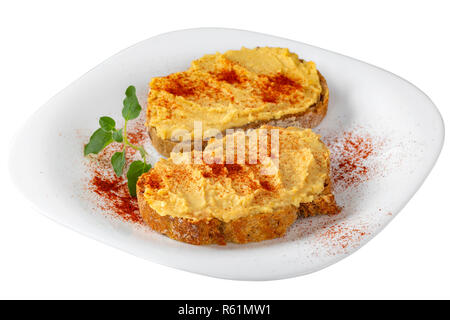 Deux sandwiches ouverts d'hummus et paprika en poudre sur la plaque sur fond blanc isolé avec clipping path Banque D'Images