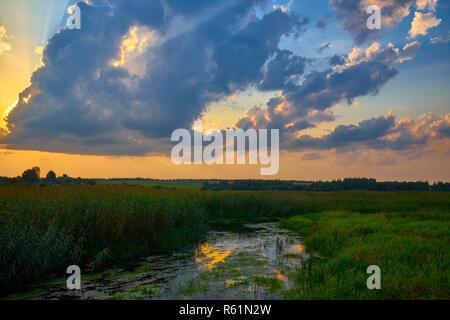 Magnifique coucher de soleil sur la rivière sous ciel nuageux. Bélarus Banque D'Images